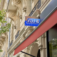 Visuel d'un point de vente FDJ à Paris, avec l'enseigne lumineuse.